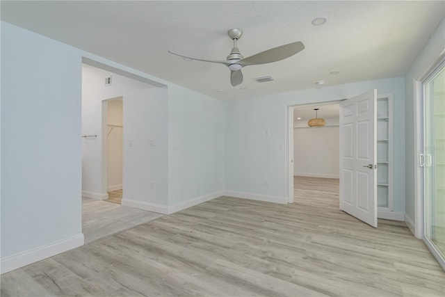 1152 Jackmar Rd, Dunedin, FL 34698 - unfurnished bedroom with a spacious closet, a closet, light wood-style flooring, and a ceiling fan