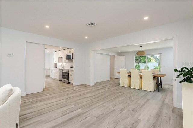 1152 Jackmar Rd, Dunedin, FL 34698 - living room with light wood finished floors, recessed lighting, and baseboards
