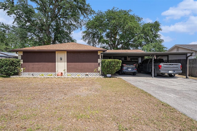garage with fence, driveway, and an attached carport