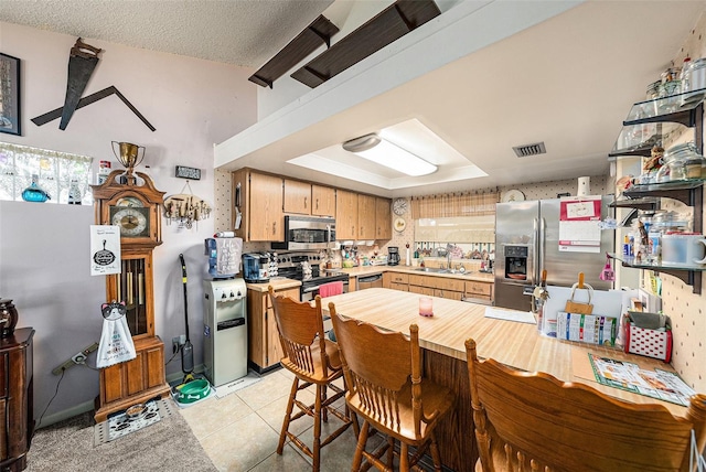 616 Highview Cir S, Brandon, FL 33510 - kitchen with stainless steel appliances, light countertops, light tile patterned floors, and a raised ceiling