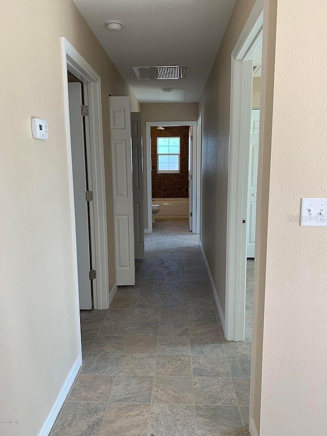 1 Pecan Course Cir, Ocala, FL 34472 - hallway featuring baseboards, visible vents, and stone finish floor