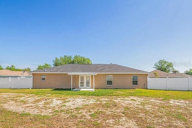 1 Pecan Course Cir, Ocala, FL 34472 - rear view of property with a fenced backyard, a yard, and french doors