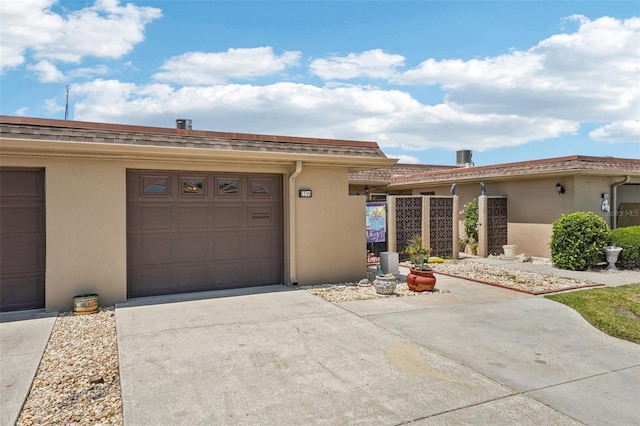 view of front of home with stucco siding, driveway, and a garage