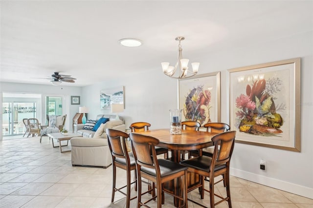 dining room with light tile patterned floors, baseboards, and ceiling fan with notable chandelier