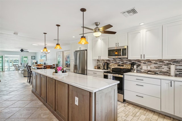 kitchen featuring stainless steel appliances, backsplash, a ceiling fan, and visible vents