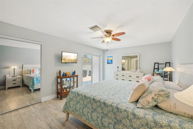 bedroom with light wood finished floors, visible vents, baseboards, and ceiling fan