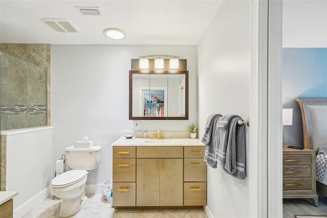 bathroom with vanity, toilet, baseboards, and visible vents
