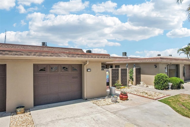 view of front of home featuring stucco siding, driveway, and a garage
