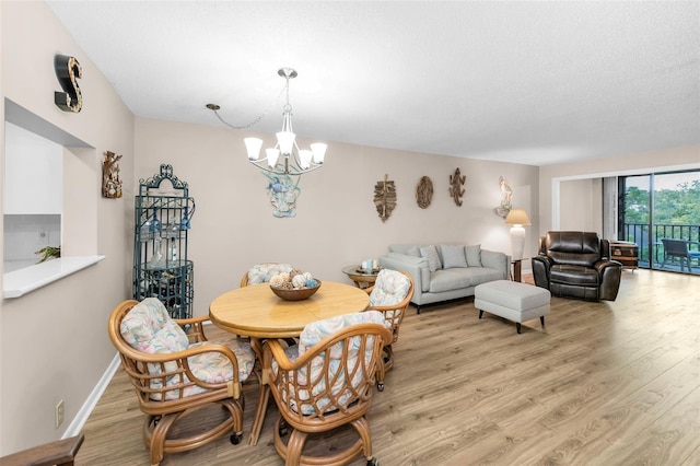 dining room with light wood-style flooring and a chandelier