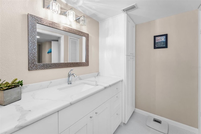 bathroom with tile patterned flooring, vanity, and baseboards