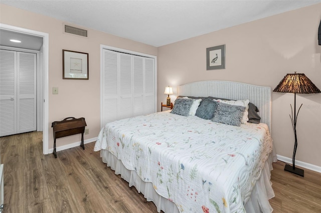 bedroom with wood finished floors, baseboards, and a closet