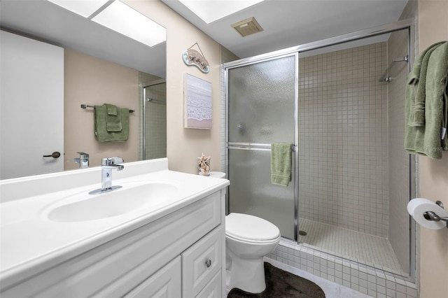 bathroom featuring a shower stall, toilet, vanity, and tile patterned flooring
