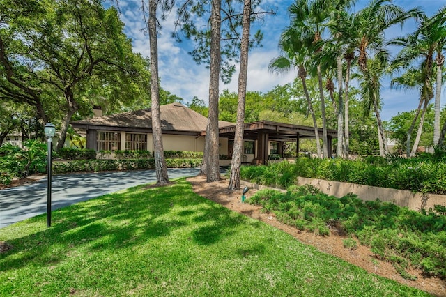 mid-century modern home featuring a front yard and a chimney