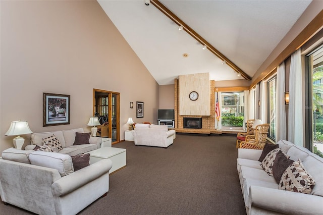 carpeted living room featuring track lighting, plenty of natural light, high vaulted ceiling, and a large fireplace