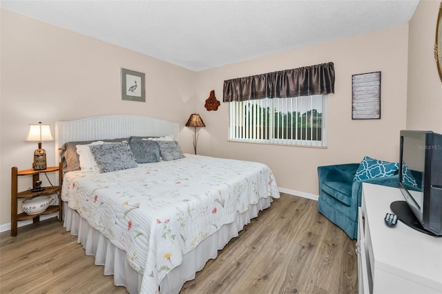 bedroom featuring baseboards and light wood-type flooring
