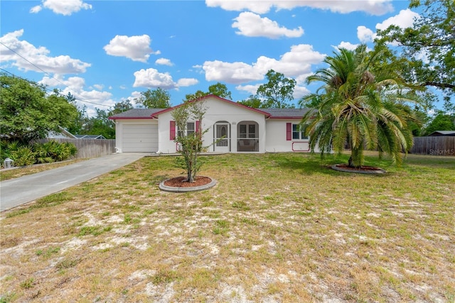 mediterranean / spanish home with fence, a garage, stucco siding, a front yard, and driveway