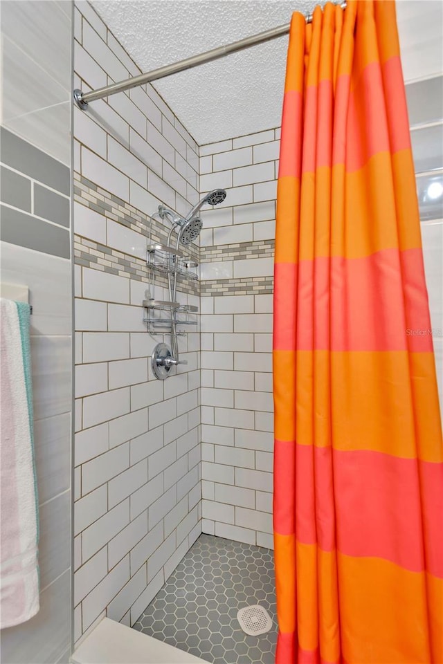 bathroom with a shower stall and a textured ceiling
