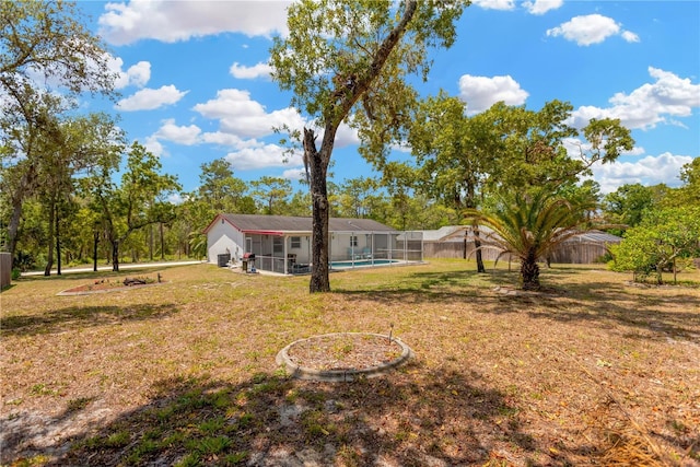 view of yard with a fenced in pool, a fenced backyard, and glass enclosure