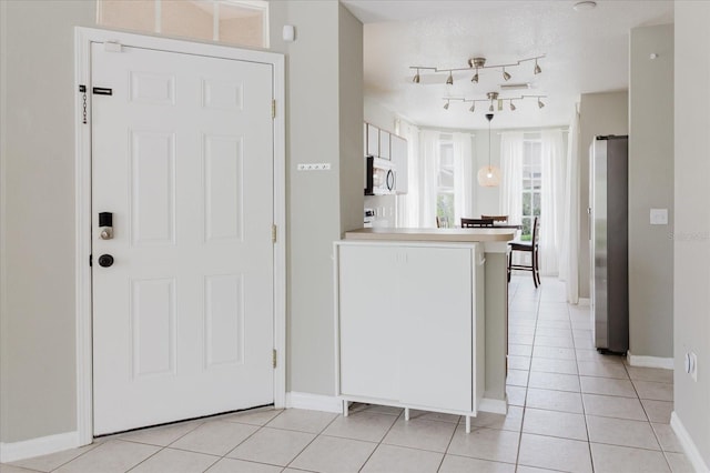6260 Olivedale Dr, Riverview, FL 33578 - kitchen featuring freestanding refrigerator, a peninsula, light tile patterned flooring, baseboards, and light countertops