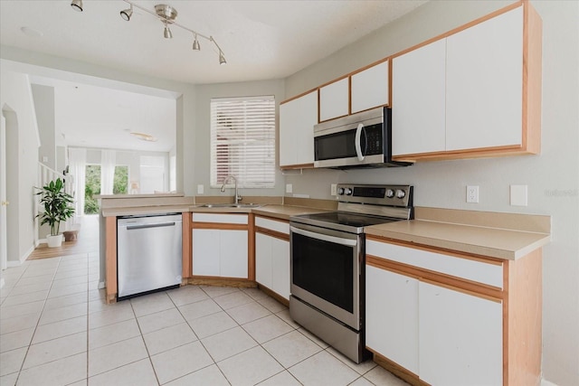 6260 Olivedale Dr, Riverview, FL 33578 - kitchen featuring appliances with stainless steel finishes, a sink, white cabinets, light countertops, and light tile patterned floors