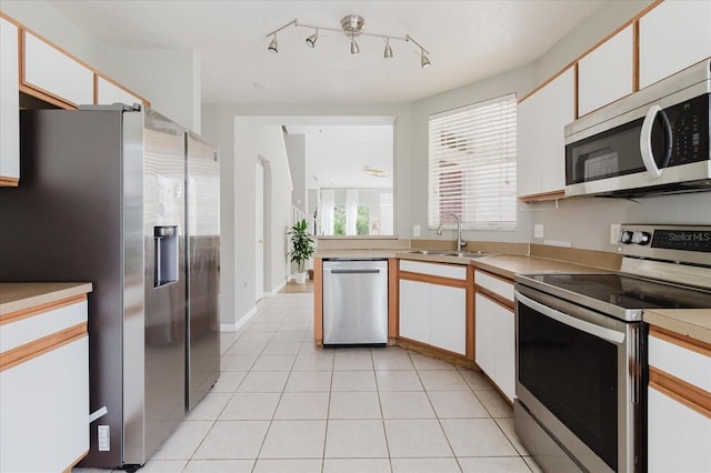 6260 Olivedale Dr, Riverview, FL 33578 - kitchen with stainless steel appliances, a sink, light tile patterned floors, and white cabinets
