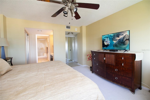bedroom with baseboards, light colored carpet, a textured ceiling, and visible vents