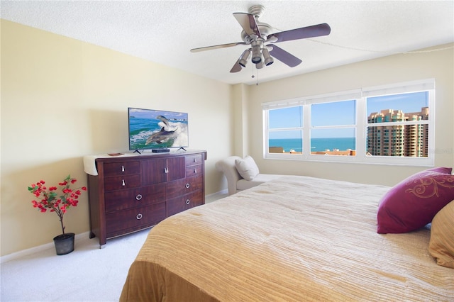 bedroom with baseboards, ceiling fan, and light carpet