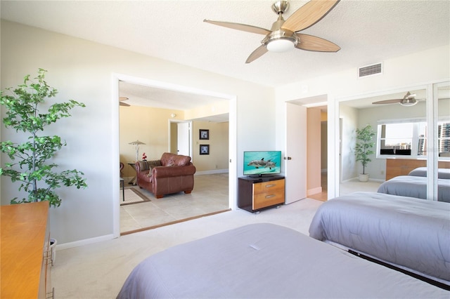 bedroom with light colored carpet, baseboards, visible vents, and a ceiling fan