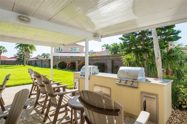 view of patio featuring a fenced backyard, grilling area, and an outdoor kitchen