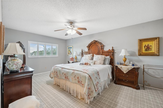 bedroom featuring baseboards, a ceiling fan, a textured ceiling, and light colored carpet
