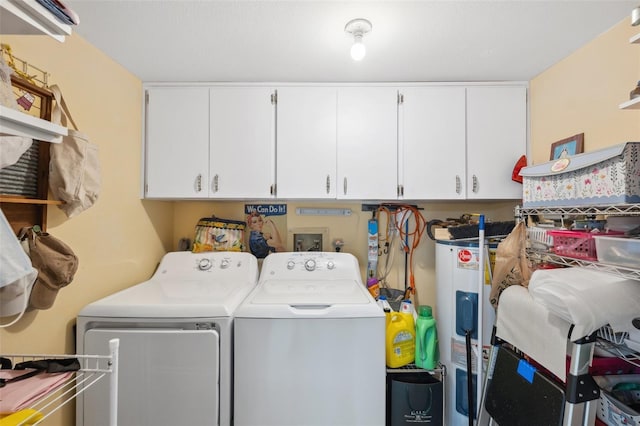 clothes washing area with washing machine and clothes dryer, water heater, and cabinet space