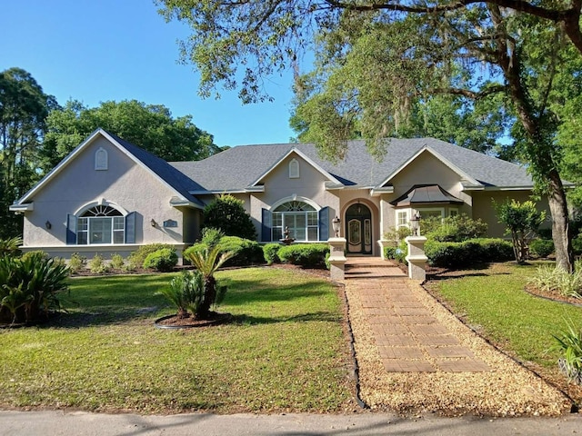 ranch-style house featuring stucco siding and a front yard