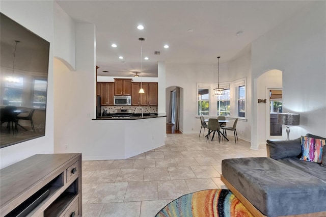 16516 Bridgewalk Dr, Lithia, FL 33547 - kitchen featuring recessed lighting, decorative backsplash, arched walkways, dark countertops, and appliances with stainless steel finishes