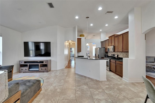 16516 Bridgewalk Dr, Lithia, FL 33547 - kitchen with dark countertops, stainless steel appliances, open floor plan, and arched walkways