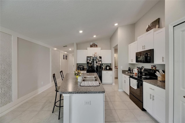 11707 Sunburst Marble Rd, Riverview, FL 33579 - kitchen with black appliances, dark countertops, a kitchen breakfast bar, a sink, and a center island with sink