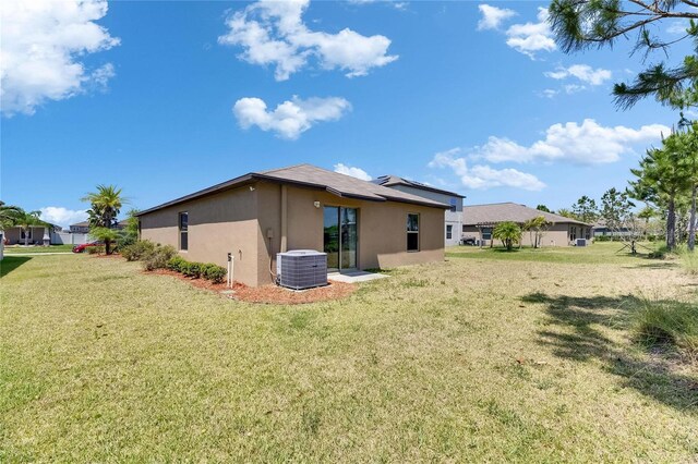 11707 Sunburst Marble Rd, Riverview, FL 33579 - back of house with stucco siding, central AC unit, and a lawn
