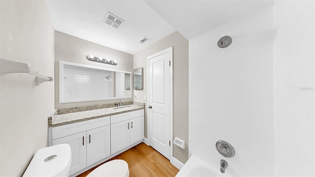 bathroom with vanity, toilet, wood finished floors, and visible vents