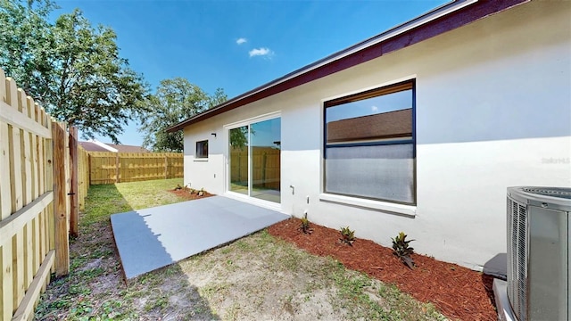 exterior space featuring central air condition unit, stucco siding, a fenced backyard, and a patio area