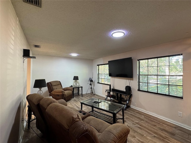 1703 N Taylor Rd, Brandon, FL 33510 - living room featuring a textured ceiling, visible vents, and wood finished floors