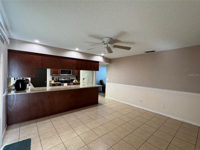 1703 N Taylor Rd, Brandon, FL 33510 - kitchen with light tile patterned flooring, light stone counters, stainless steel appliances, a ceiling fan, and a peninsula