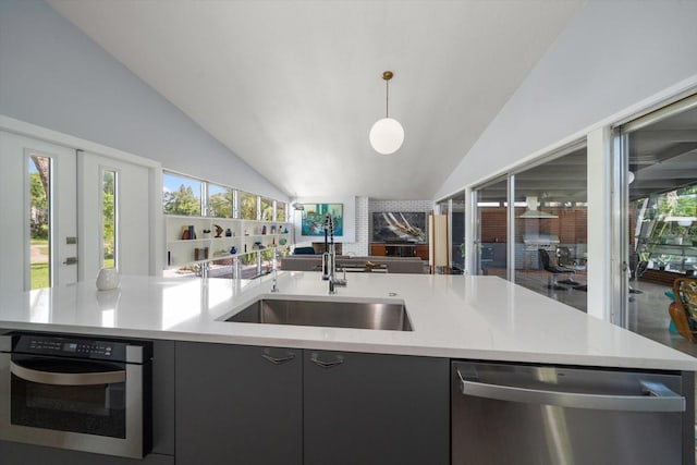 kitchen featuring appliances with stainless steel finishes, a sink, open floor plan, vaulted ceiling, and a center island with sink
