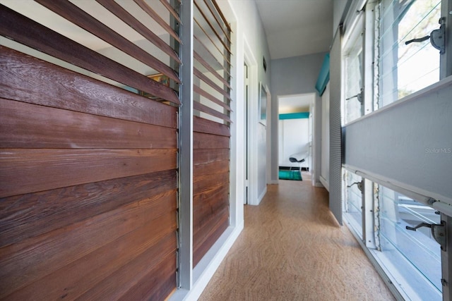 corridor with baseboards and carpet flooring