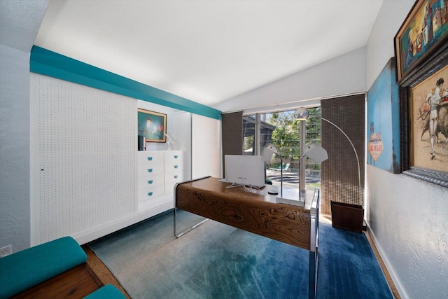carpeted home office featuring baseboards and lofted ceiling