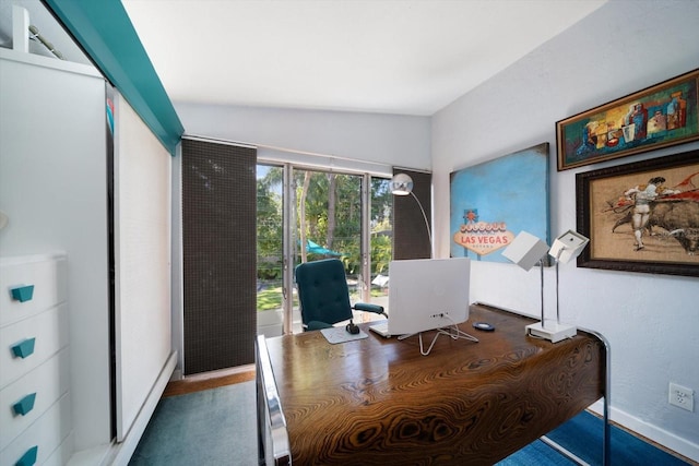 office featuring baseboards and lofted ceiling