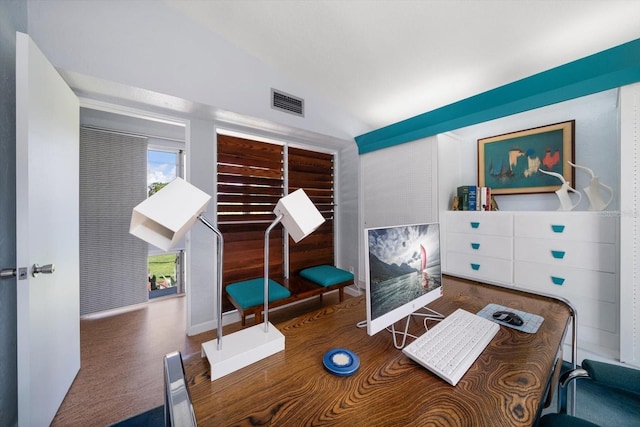 office with vaulted ceiling, wood finished floors, and visible vents