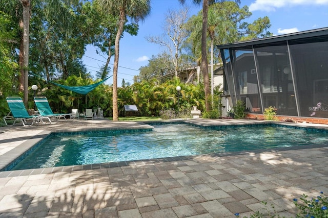 pool with a sunroom and a patio area