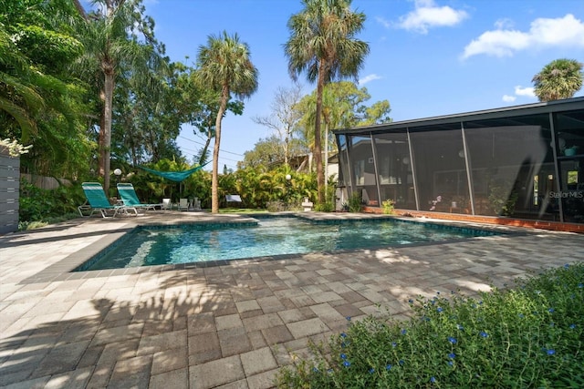 pool with a sunroom and a patio area