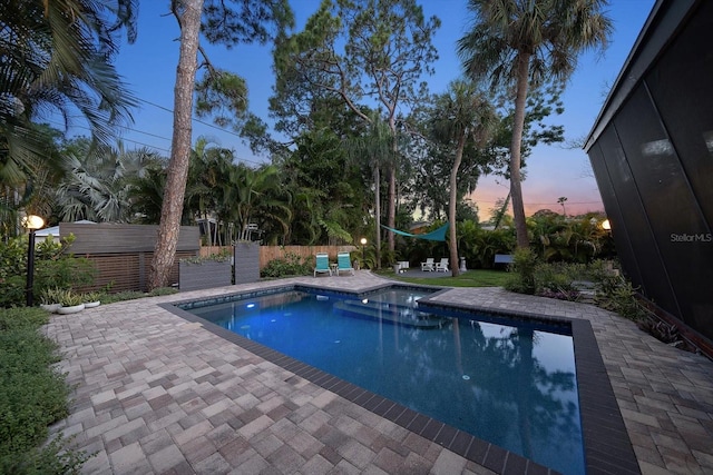 outdoor pool with a patio and fence