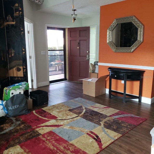 foyer featuring baseboards and wood finished floors