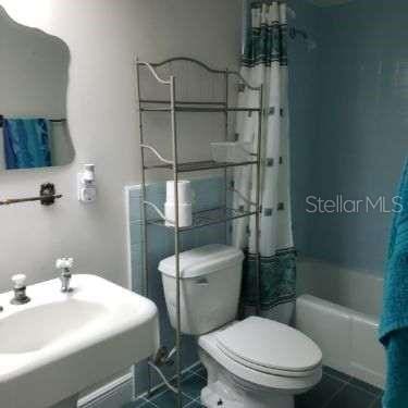 bathroom with tile patterned flooring, toilet, and shower / tub combo